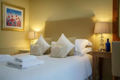 a bedroom with a white bed with towels on it at Derwent in Keswick