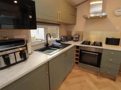 a kitchen with a sink and a stove top oven at Seren in Cockermouth