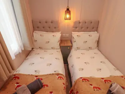 two twin beds in a small room with christmas blankets at Seren in Cockermouth
