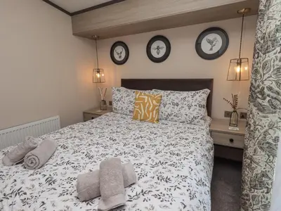 a bedroom with a bed and three clocks on the wall at Haven in Cockermouth