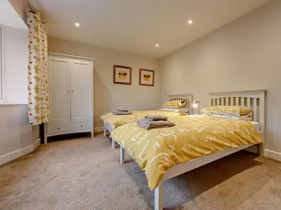two beds in a bedroom with yellow bedding at 3 Bed in Keswick oc-93589 in Threlkeld
