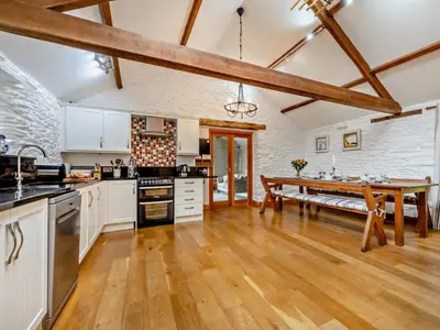 a kitchen with white cabinets and a wooden table at 3 Bed in Keswick oc-93590 in Threlkeld