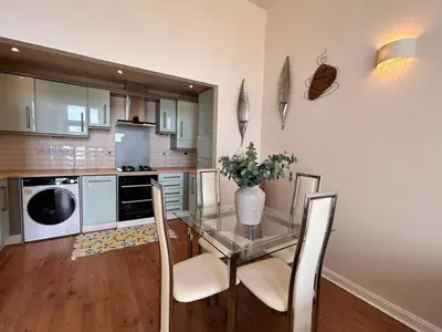 a kitchen with a glass table with a vase of flowers at Marina 2bedroom Beach Nearby Swansea City in Moffat