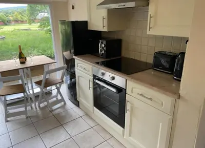 a kitchen with a table and a stove top oven at Riverbank Cottage River Ehan Double Balcony in Egremont