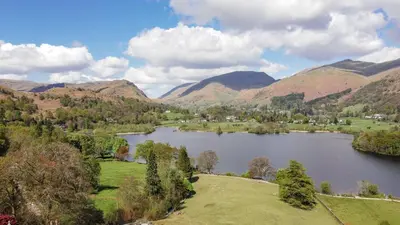 a lake in the middle of a valley with mountains at Poet's View Cottage in Grasmere