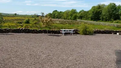 a white picnic table sitting in a gravel field at The Old Dairy in Lochfoot