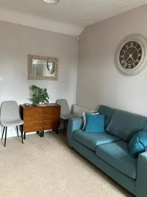 a living room with a blue couch and a table at Wee Lyon Cottage Maybole 2 Bedroom Sleeps 4 in Maybole