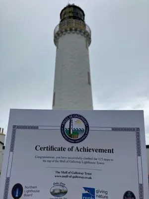 a sign in front of a lighthouse with a certificate of achievement at Wee Lyon Cottage Maybole 2 Bedroom Sleeps 4 in Maybole
