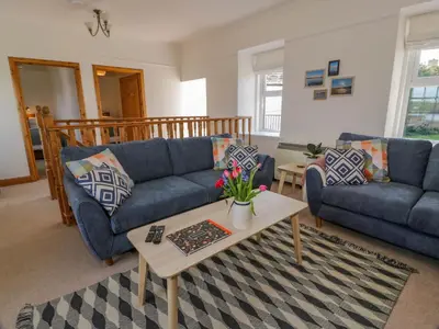 a living room with blue couches and a coffee table at 2Loos in Newton Stewart