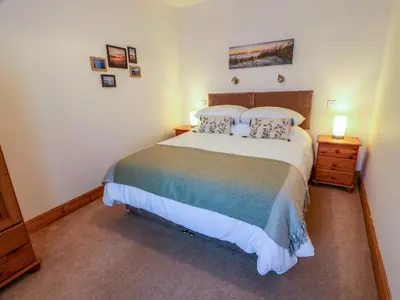 a bedroom with a large bed with two pillows at 2Loos in Newton Stewart