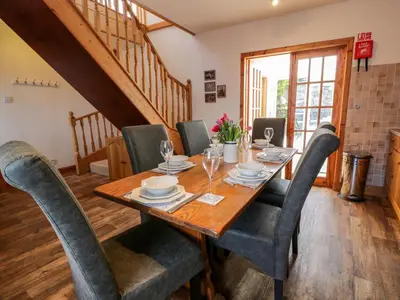 a dining room with a wooden table and chairs at 2Loos in Newton Stewart