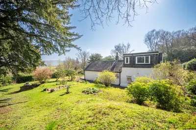 a house in the middle of a yard at The Stables Cottage, Beattock, Moffat in Beattock