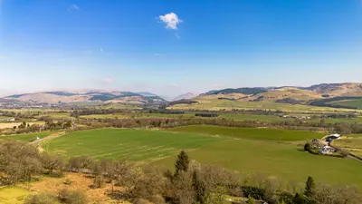 a green field with mountains in the background at The Stables Cottage, Beattock, Moffat in Beattock