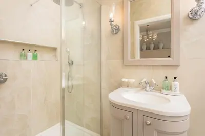 a white bathroom with a shower and a sink at No36 South Beach - Donnini Apartments in Troon