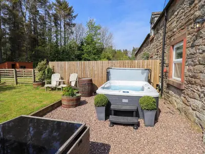 a backyard with a hot tub in a yard at Corner Cottage in Penrith
