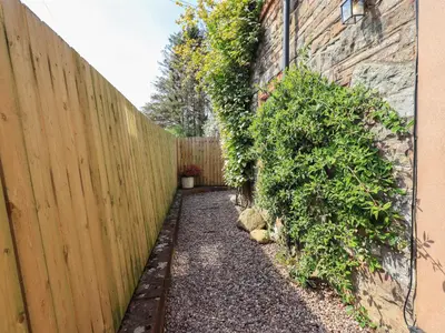 a fence in a yard next to a building at Corner Cottage in Penrith
