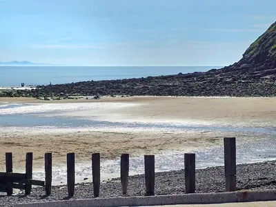 a fence on a beach near the water at The St Bees Knees in St Bees