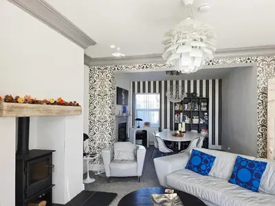 a living room with a white couch and a chandelier at The St Bees Knees in St Bees