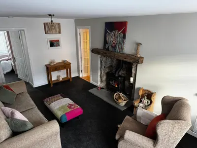 a living room with two couches and a fireplace at Cosy Wee Cottage in Monkton