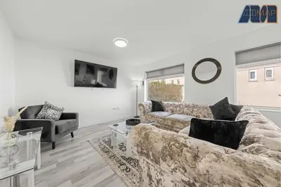 a living room with a couch and a table at 3BR Home in Kilmarnock Sleeps 6 in Kilmarnock