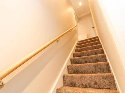 a staircase in a home with carpeted stairs at Grace House in Wigton