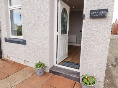 a front door of a house with two potted plants at Grace House in Wigton
