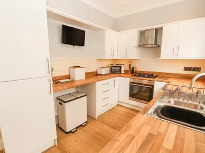 a kitchen with white cabinets and a sink at Grace House in Wigton