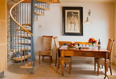 a dining room with a table and chairs and a staircase at Lighthouse Studio Apartment in Portpatrick
