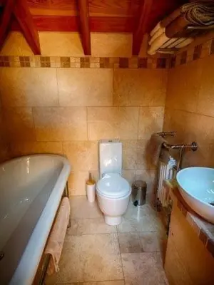 a bathroom with a toilet and a tub and a sink at Lighthouse Studio Apartment in Portpatrick