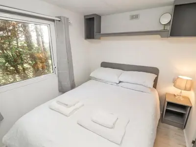 a small bedroom with a white bed and a window at No 29 Wyndham Hall in Cockermouth