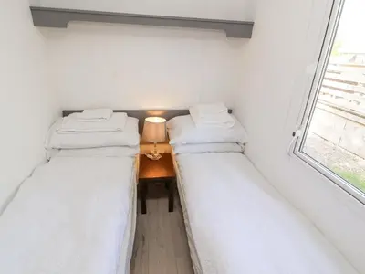 two beds in a small room with a window at No 29 Wyndham Hall in Cockermouth