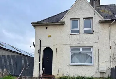 a white house with a black door and a fence at Chic & Cozy 2BR Semi-Detached in Kilmarnock