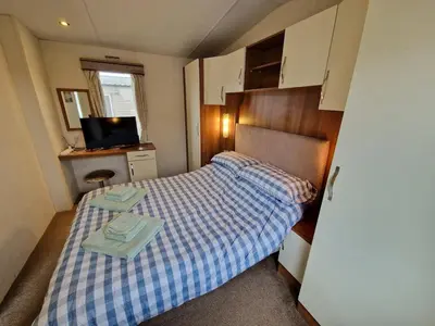 a small bedroom with a bed and a television at Peaceful Seaside Getaway in Mainsriddle
