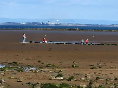 a group of people walking on the beach at Peaceful Seaside Getaway in Mainsriddle
