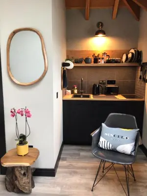 a room with a chair and a mirror and a table at Lightkeepers Snug in Portpatrick