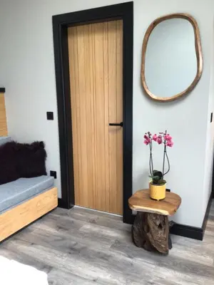 a room with a door and a table with a mirror at Lightkeepers Snug in Portpatrick