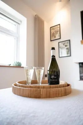 a bottle of wine and two glasses on a table at Tucked Away in Keswick