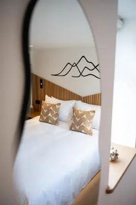 a bedroom with a bed with mountains on the wall at Tucked Away in Keswick