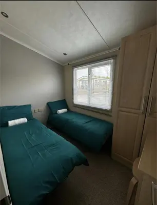 a small room with two beds and a window at Zions Retreat in Plumbland