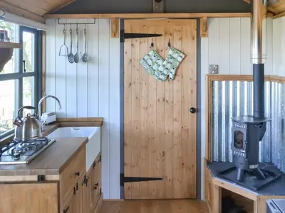 a kitchen with a stove and a door at The Shepherd's Rest in Auchencairn