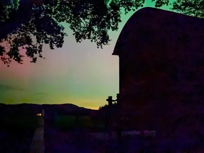 a silhouette of a church with the sunset in the background at The Shepherd's Rest in Auchencairn