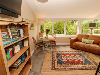 a living room with a couch and a table at Kirkland Howe Cottage in Frizington