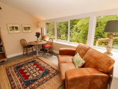 a living room with a couch and a table at Kirkland Howe Cottage in Frizington