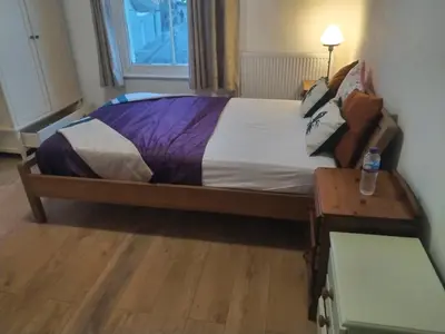 a bedroom with a bed and a table with a bottle on it at 98 Board street in Moffat