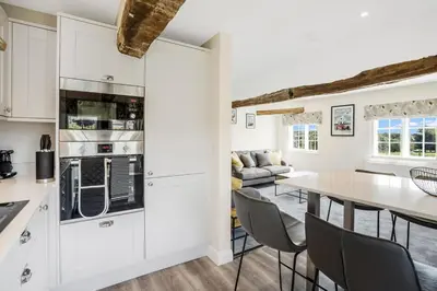 a kitchen and living room with a table and chairs at Beautiful 3 bedroom cottage close to Goodwood ! in Moffat