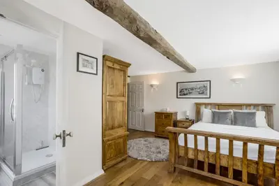 a bedroom with a bed and a walk in shower at Beautiful 3 bedroom cottage close to Goodwood ! in Moffat