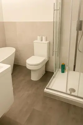 a white bathroom with a toilet and a shower at High living @ Ferguson Court in Carlisle