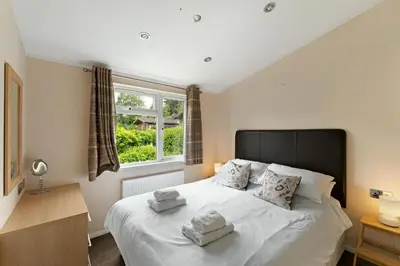 a bedroom with a large white bed with two towels on it at Troutbeck Lodge in Bassenthwaite