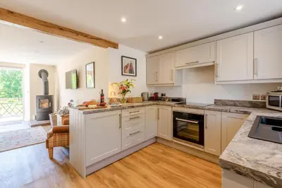 a kitchen with white cabinets and wooden floors at 2 Bed in Caldbeck oc-a32049 in Caldbeck