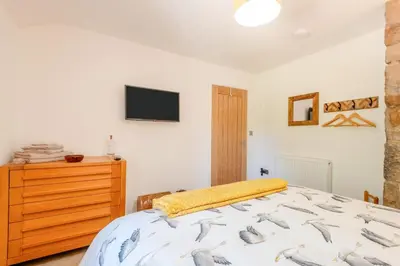 a bedroom with a bed and a tv on the wall at 2 Bed in Caldbeck oc-a32049 in Caldbeck